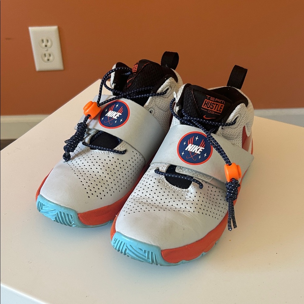 NIKE “TEAM HUSTLE” kids white/orange/blue sneakers